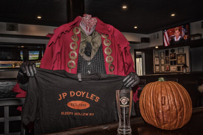 The headless horseman holds a J.P. Doyles t-shirt at the restaurant's bar.
