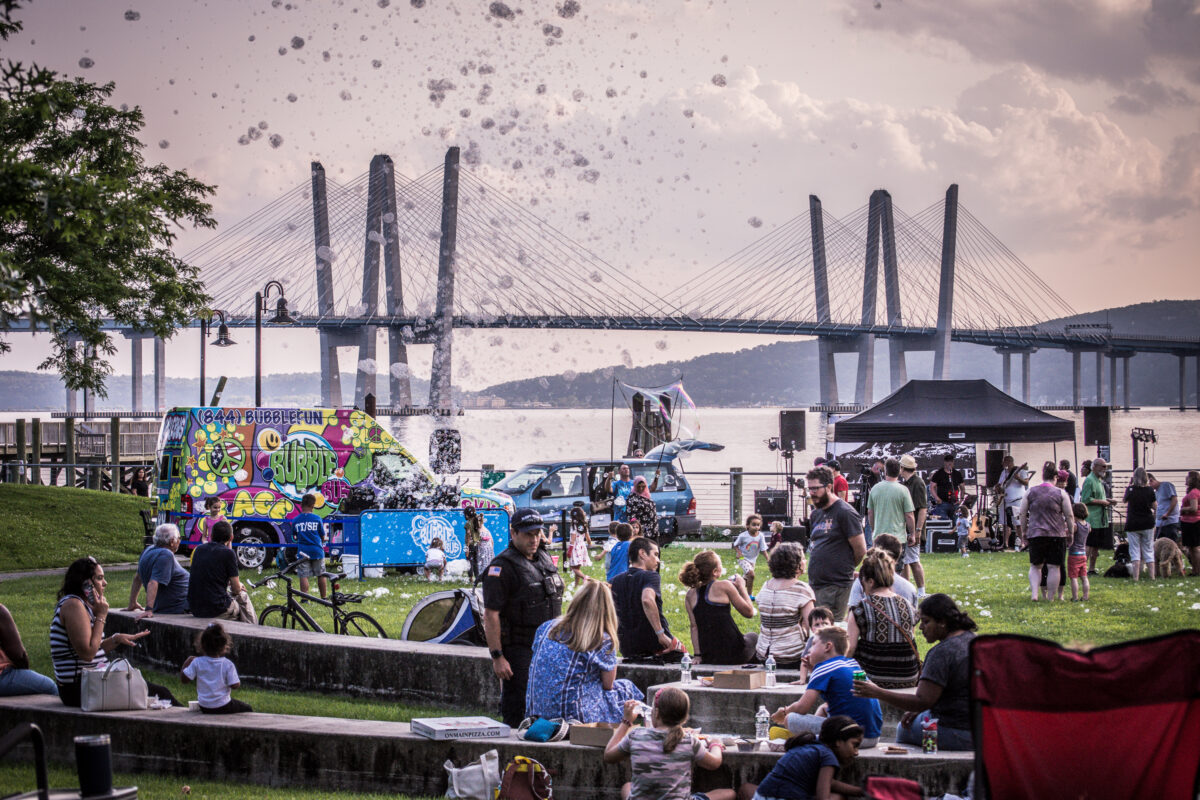 Evening concert at Horan's Landing Park with families picnicking.