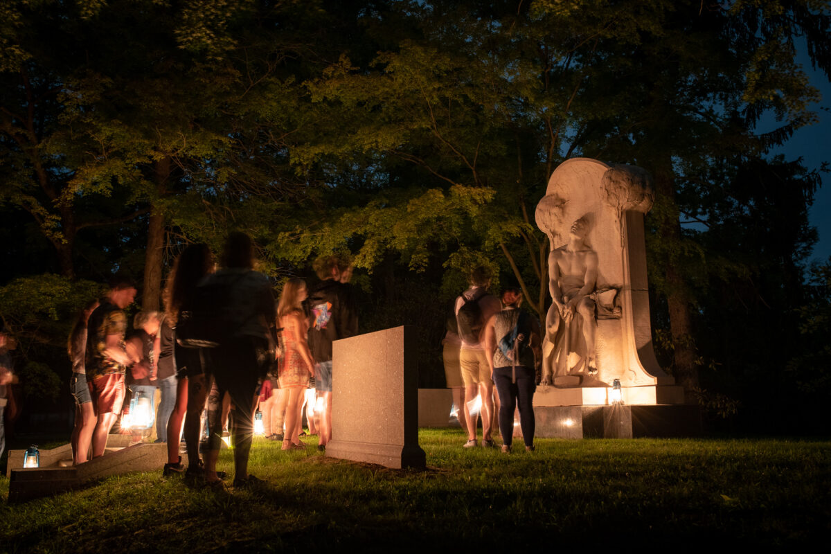 A Sleepy Hollow Cemetery lantern tour pauses at the monument of Henry Villard.