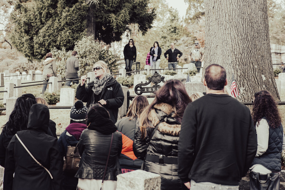 A Sleepy Hollow Cemetery walking tour pauses at the gate to Washington Irving's family lot.