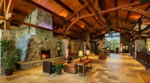A view of the Sleepy Hollow Hotel lobby showing fireplace and exposed rough hewn ceiling beams.