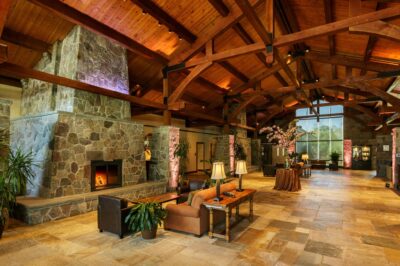 A view of the Sleepy Hollow Hotel lobby showing fireplace and exposed rough hewn ceiling beams.