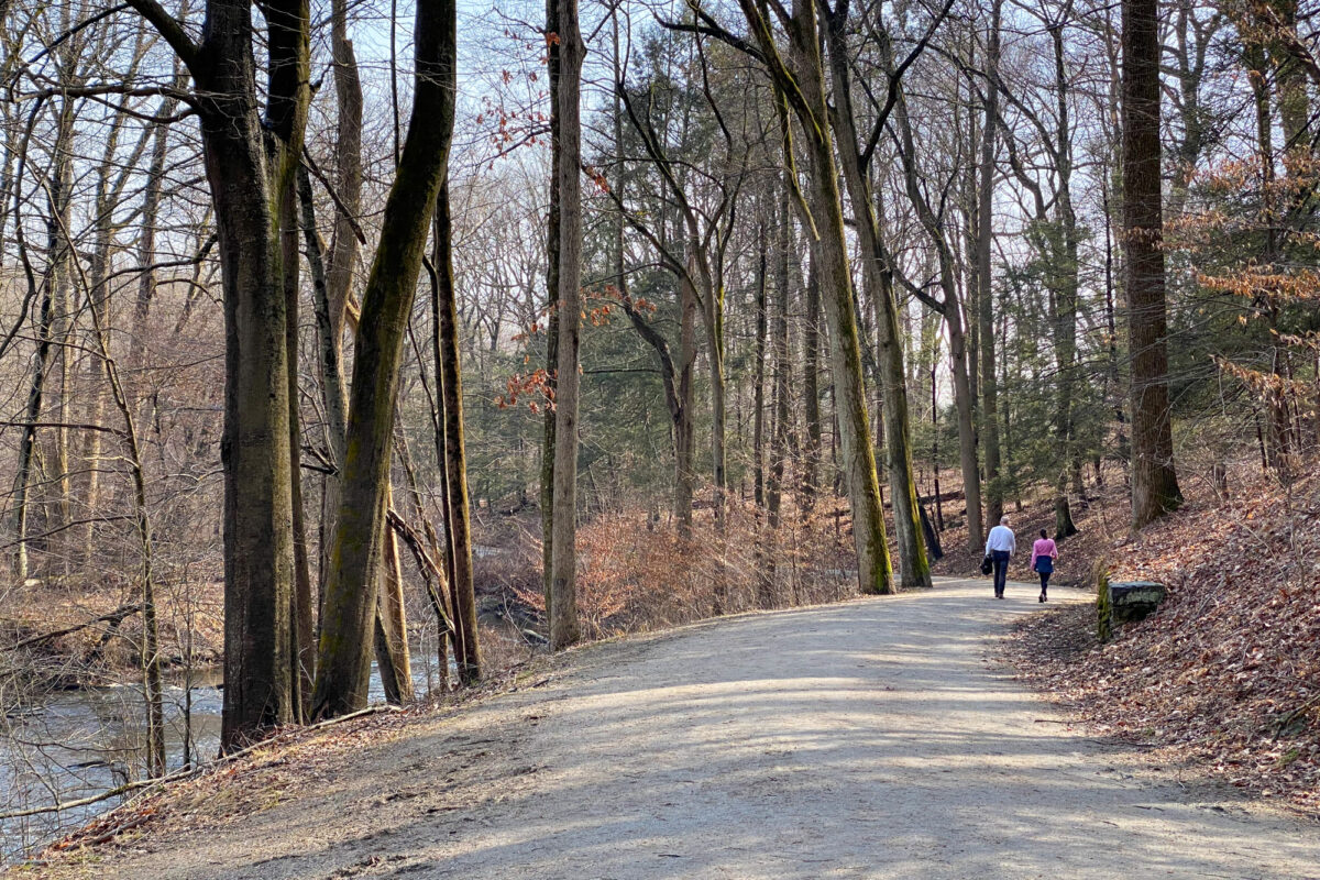 A couple walks a carriage road along the Pocantico River in Rockefeller State Park.