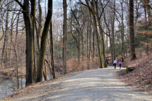 A couple walks a carriage road along the Pocantico River in Rockefeller State Park.