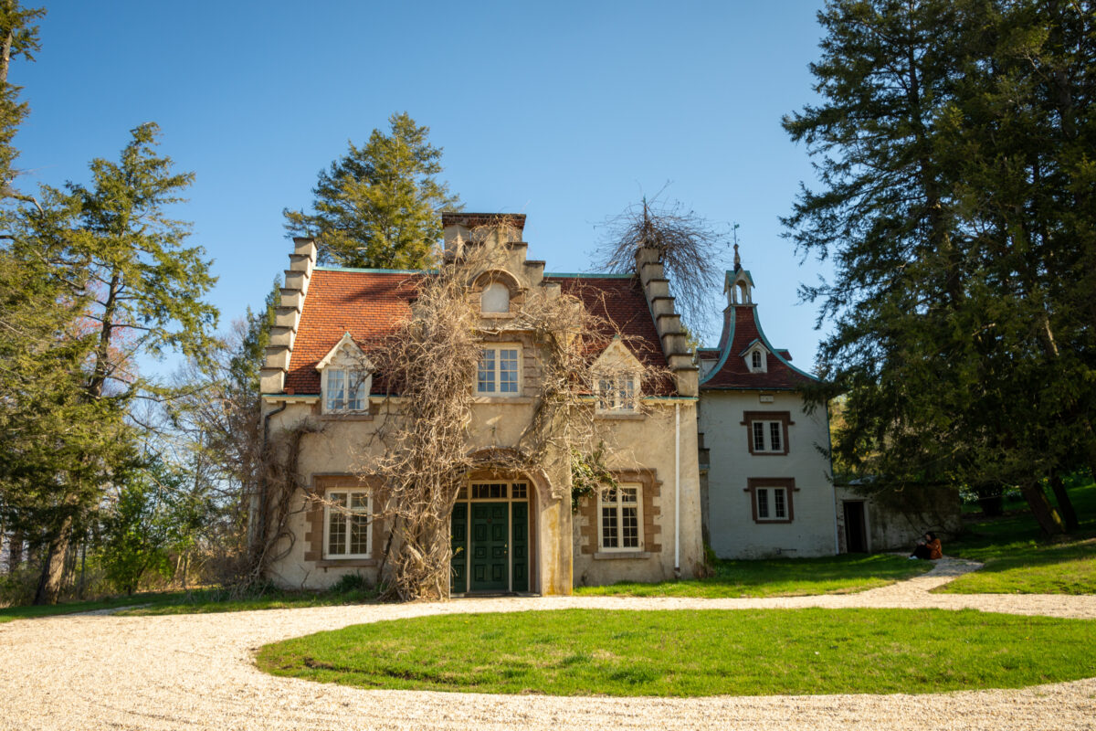 Washington Irving's home, Sunnyside, is framed by a clear, blue sky and the white gravel driveway.
