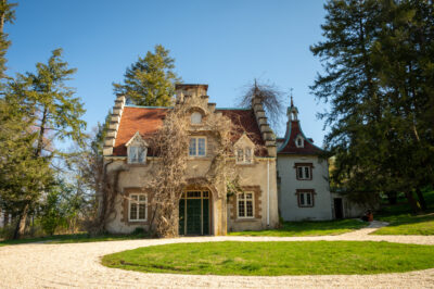 Washington Irving's home, Sunnyside, is framed by a clear, blue sky and the white gravel driveway.