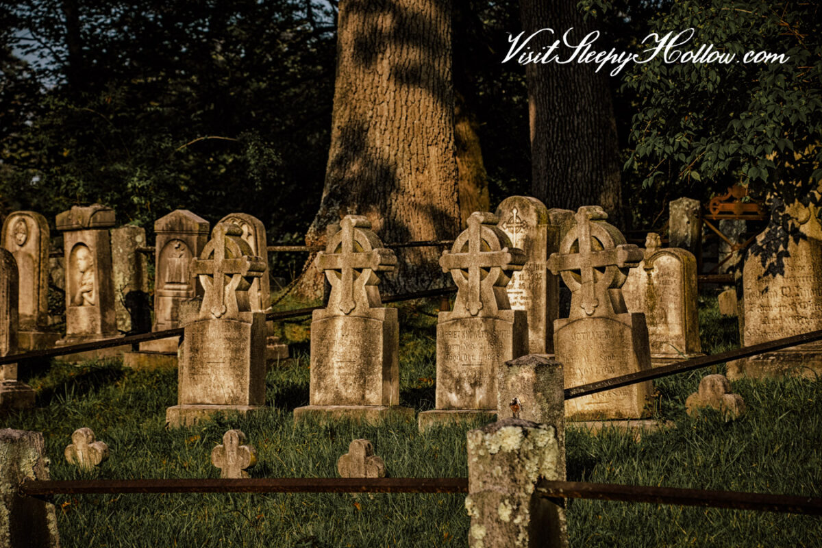 Gravestones appear on a grassy lawn in Sleepy Hollow Cemetery.