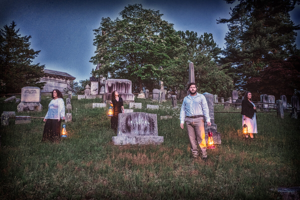 Cast of "The Hill – Stories from Spoon River" pose with lanterns in Sleepy Hollow Cemetery.